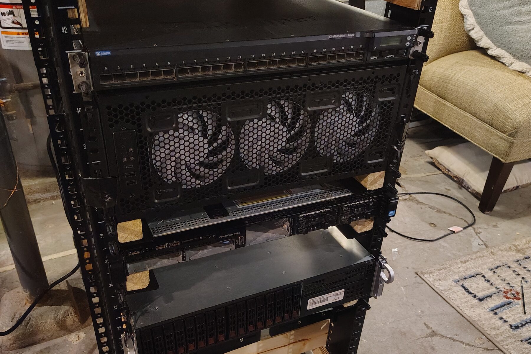 My homelab rack, with a Juniper EX4200 switch, a 4U chassis with three front fans, a Dell PowerEdge R620, and a Supermicro 2U server